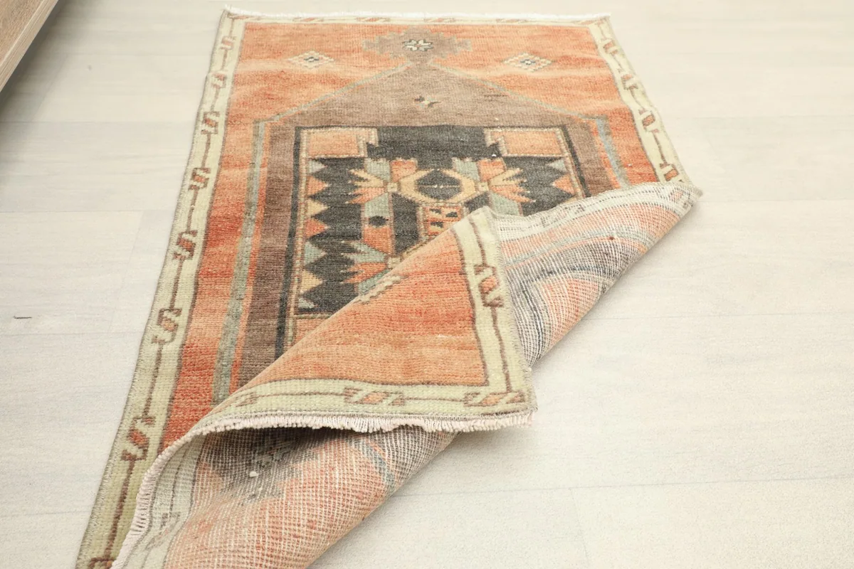 View of the rug rolled partially, revealing the low wool pile and the foundation