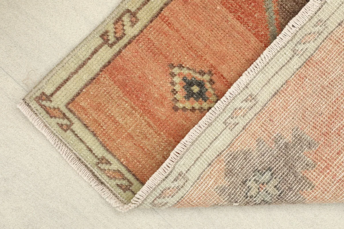 Partial view of the rug's backside, showing the hand-knotted cotton foundation