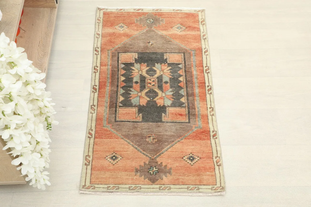 Overhead view of the hand-knotted orange, charcoal, and brown wool rug