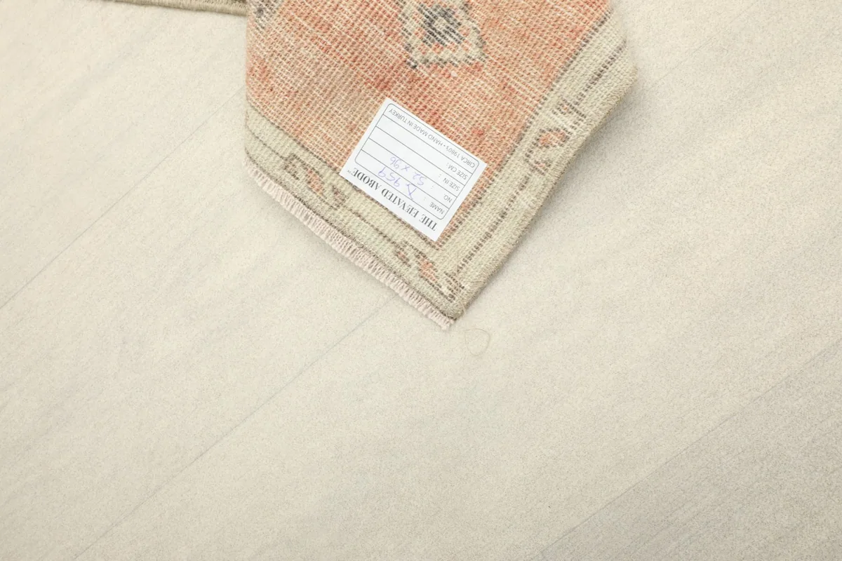 Underside corner of the rug with a label, showing the cotton foundation