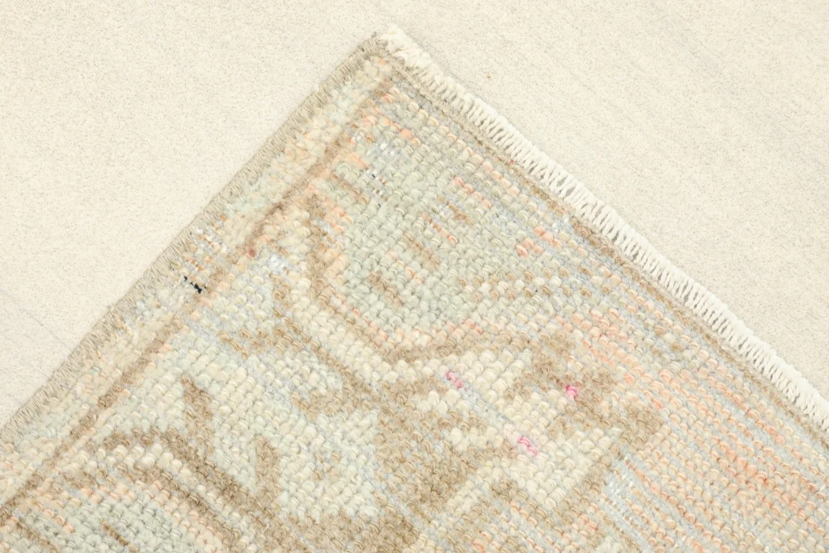 Corner detail of the rug, highlighting the subtle border design and hand-knotted edge.