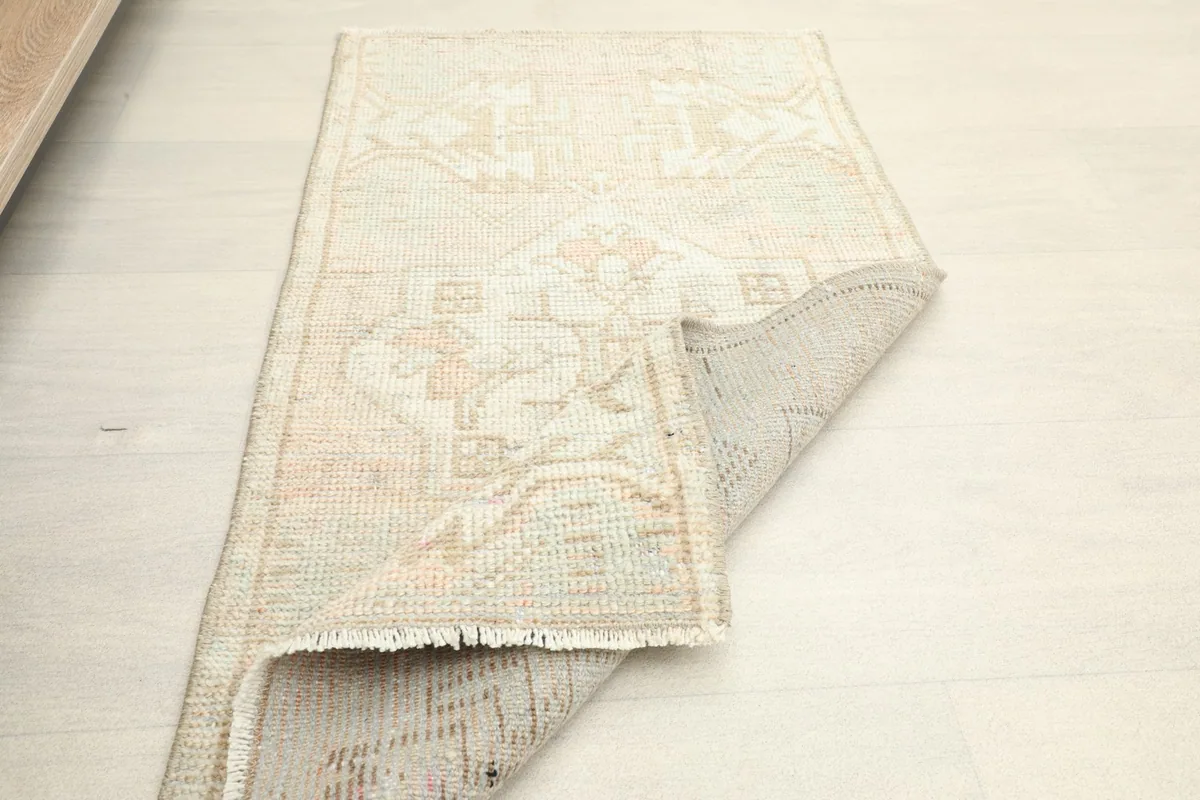The rug partially folded, demonstrating its flexibility and low pile construction.