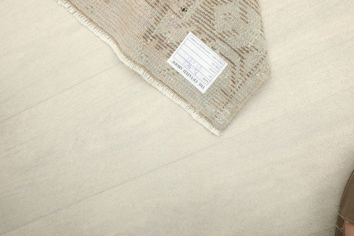 Corner of the rug with a label, showing the reverse side and weave structure.