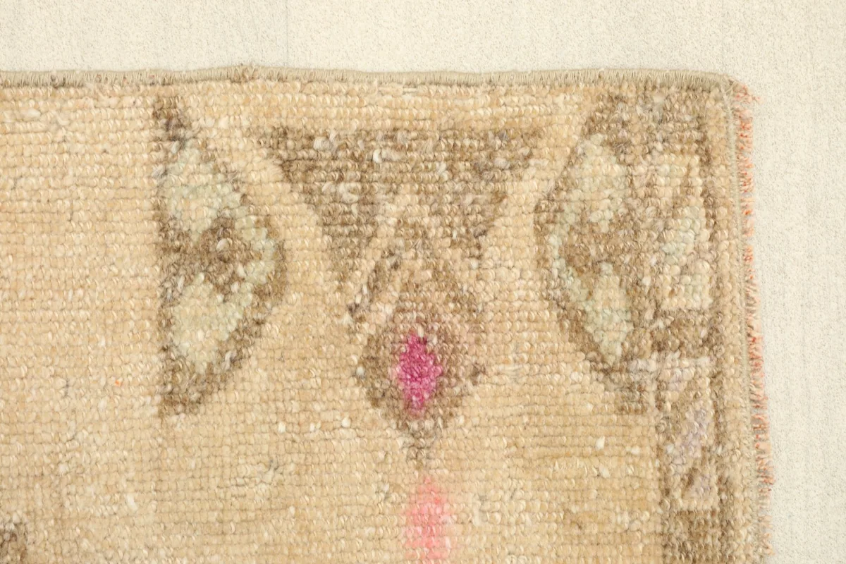 Close-up of the upper section of the rug, highlighting the tribal motifs and the rose pink accents.