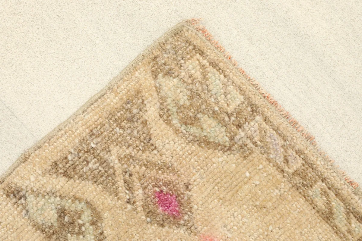 Corner detail showing the edge finishing and the subtle patterns in the beige and brown border area.