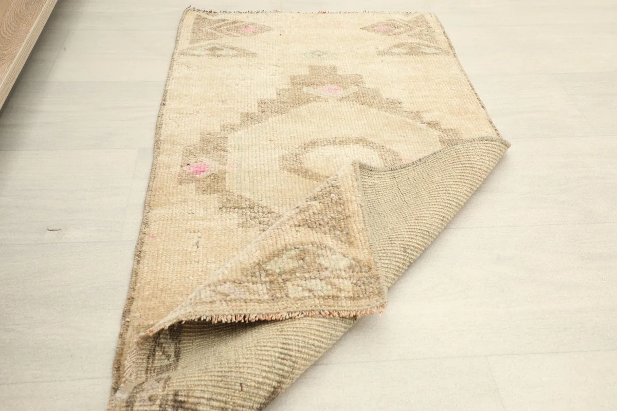 The rug partially folded back, revealing the hand-knotted cotton foundation and the reverse pattern.