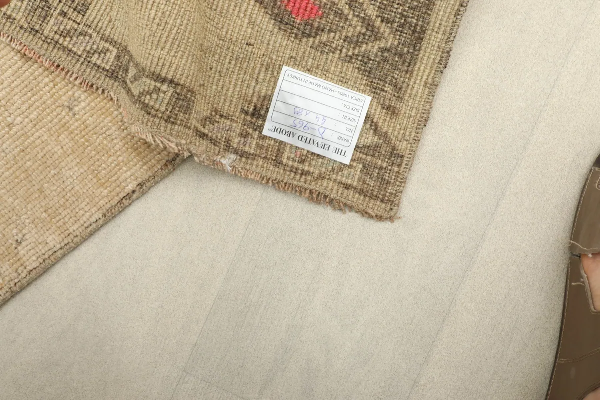 Close-up of the rug's back, showing the tightly woven cotton foundation and a product label.