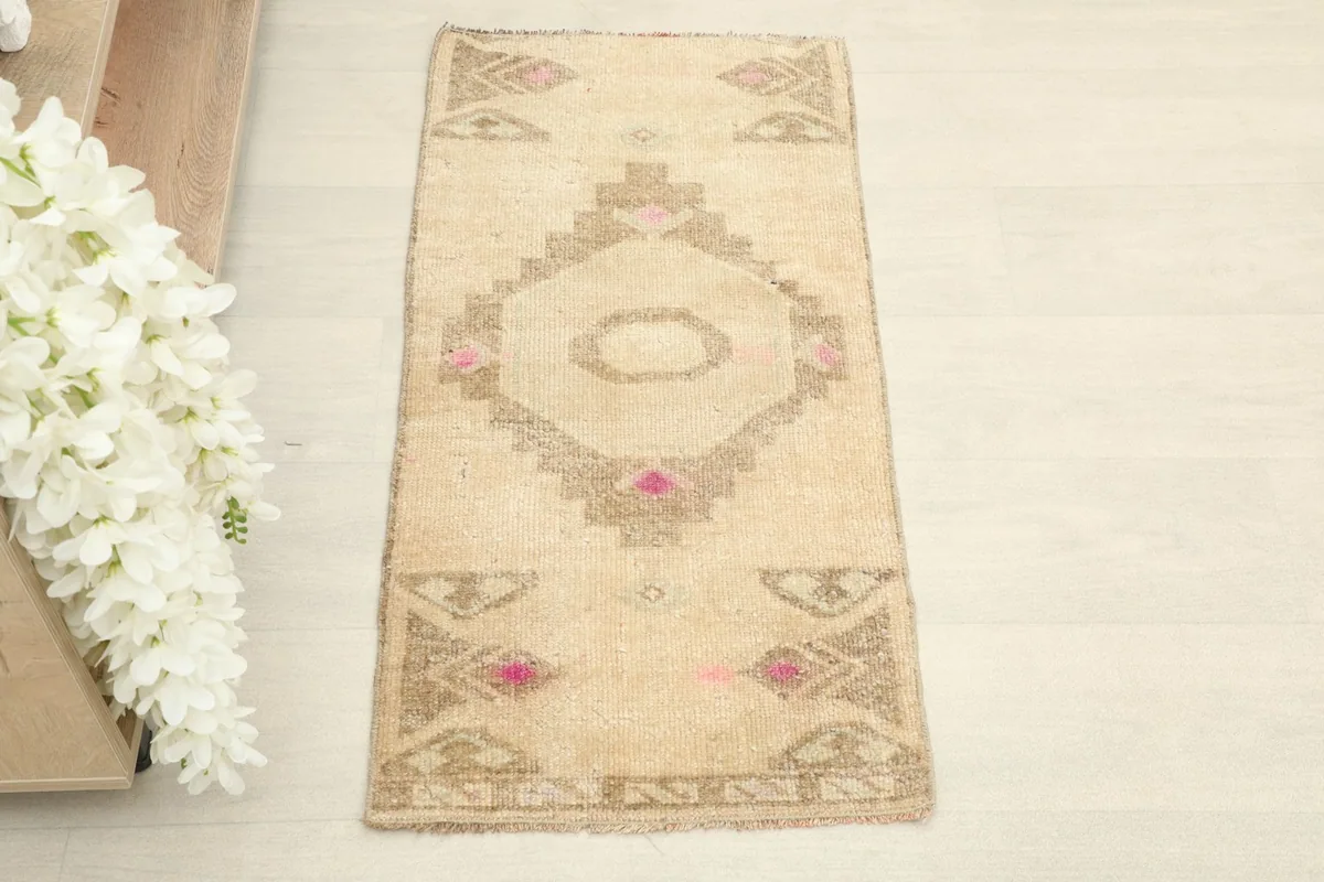 Straight overhead view showing the full pattern of the beige and brown tribal medallion rug.