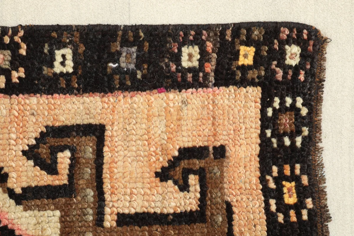 Edge view of the rug's border, highlighting the texture and colors of the hand-knotted wool.