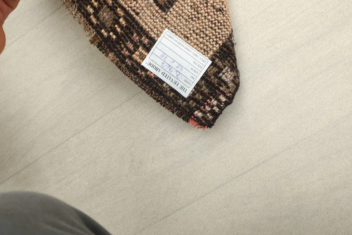 Back of the rug showing the cotton foundation and the hand-knotted construction with a label.