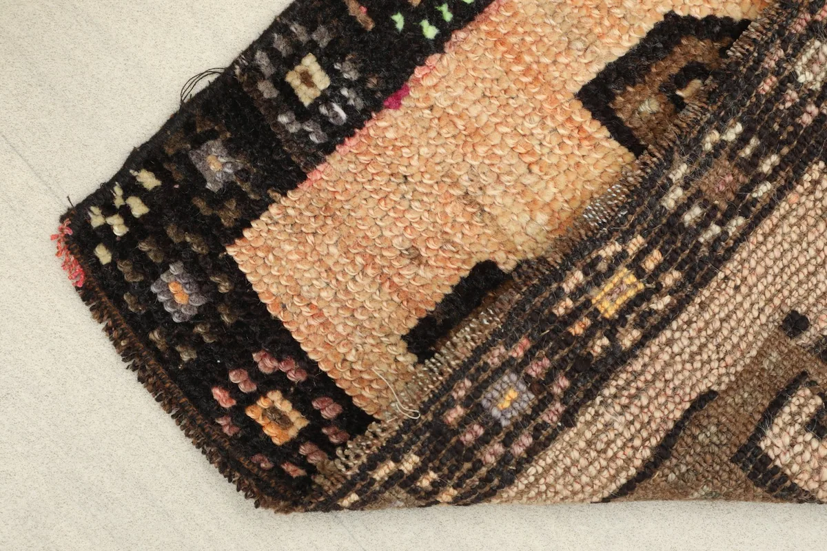 Folded rug showing the thickness of the wool pile and the construction from the side.