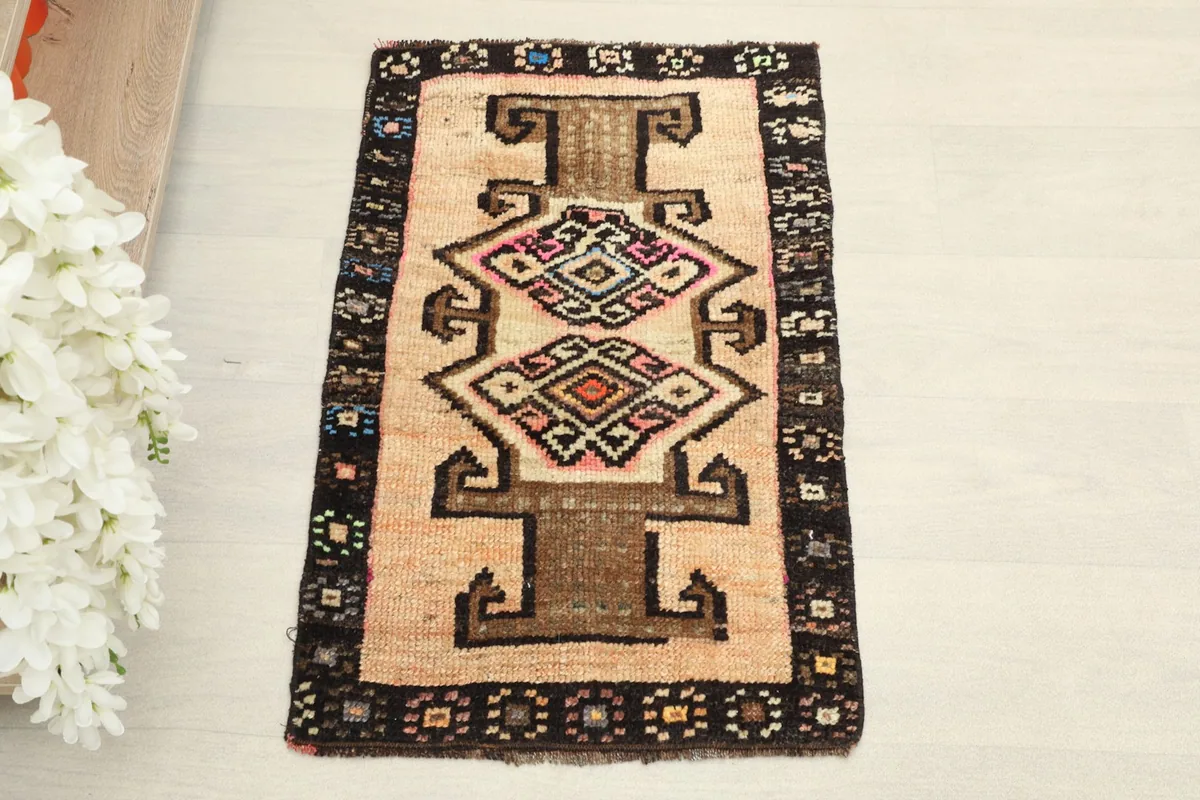 Overhead view of the vintage Anatolian rug showing the central beige field and dark border.