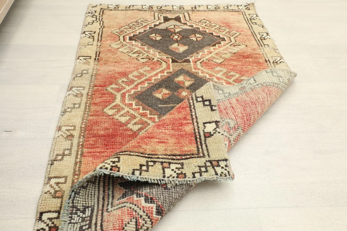 The vintage rug folded to show its flexibility and the texture of the wool pile.
