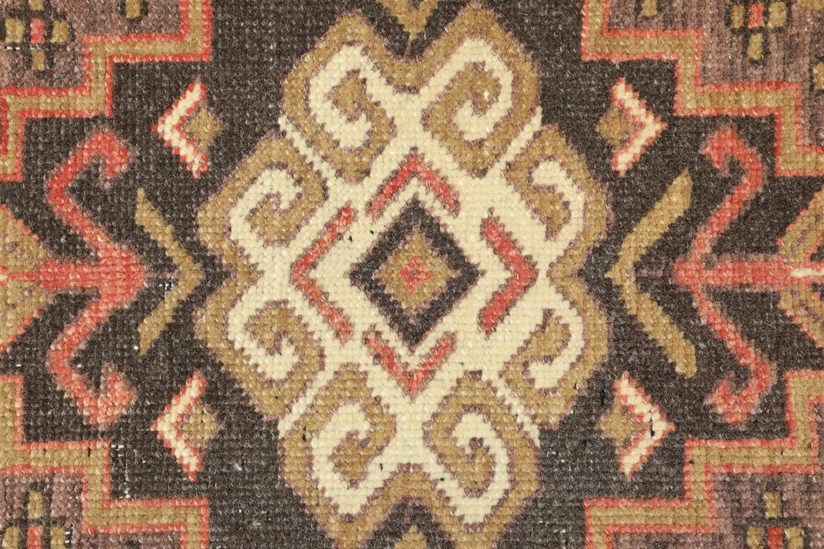 Detailed view of the intricate hand-knotted geometric patterns and colors in the rug's center.