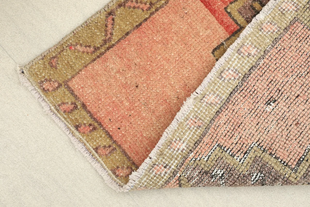 View showing the low wool pile and the hand-knotted construction of the vintage rug.