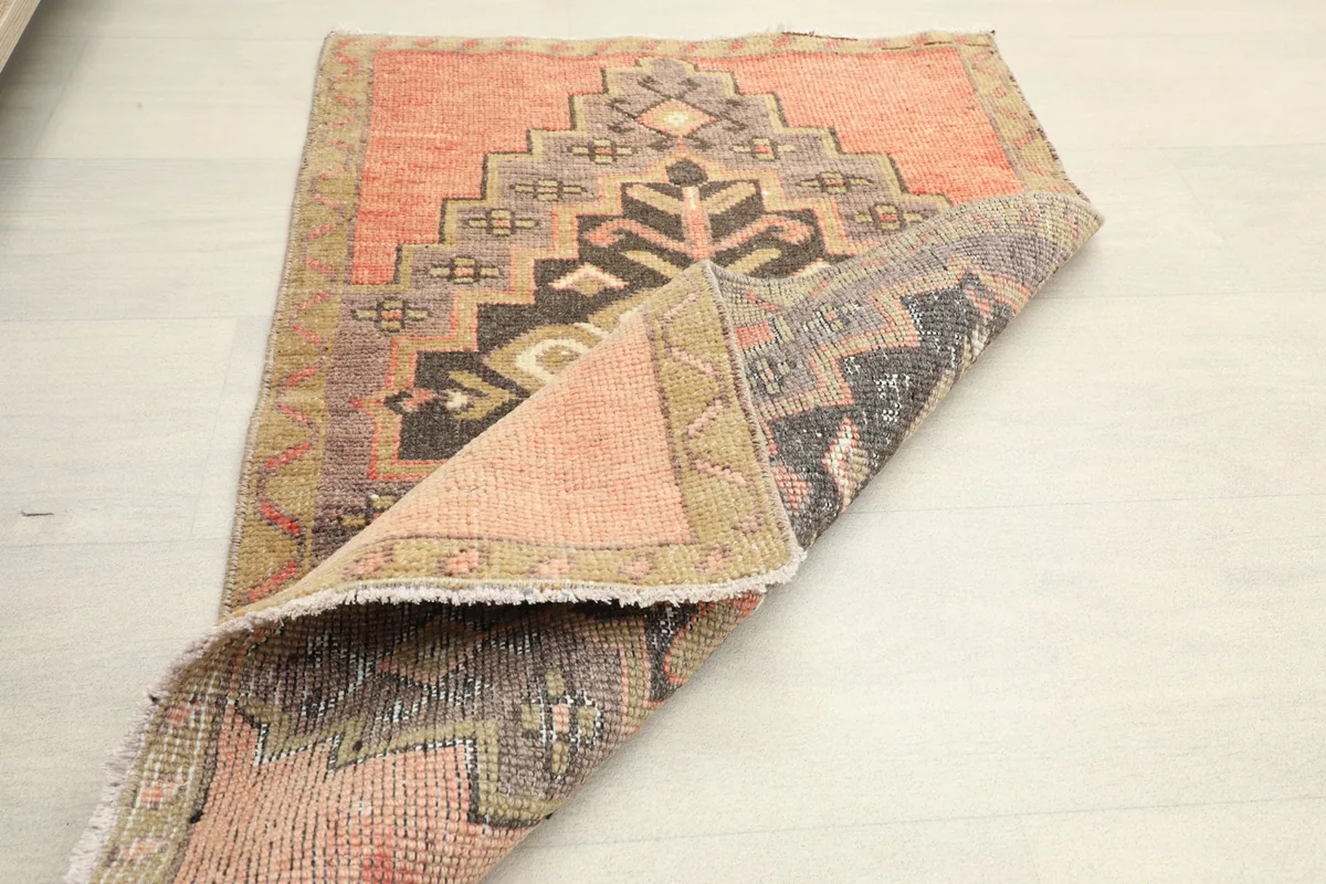 Partially folded rug displaying the back of the hand-knotted cotton foundation and wool pile.