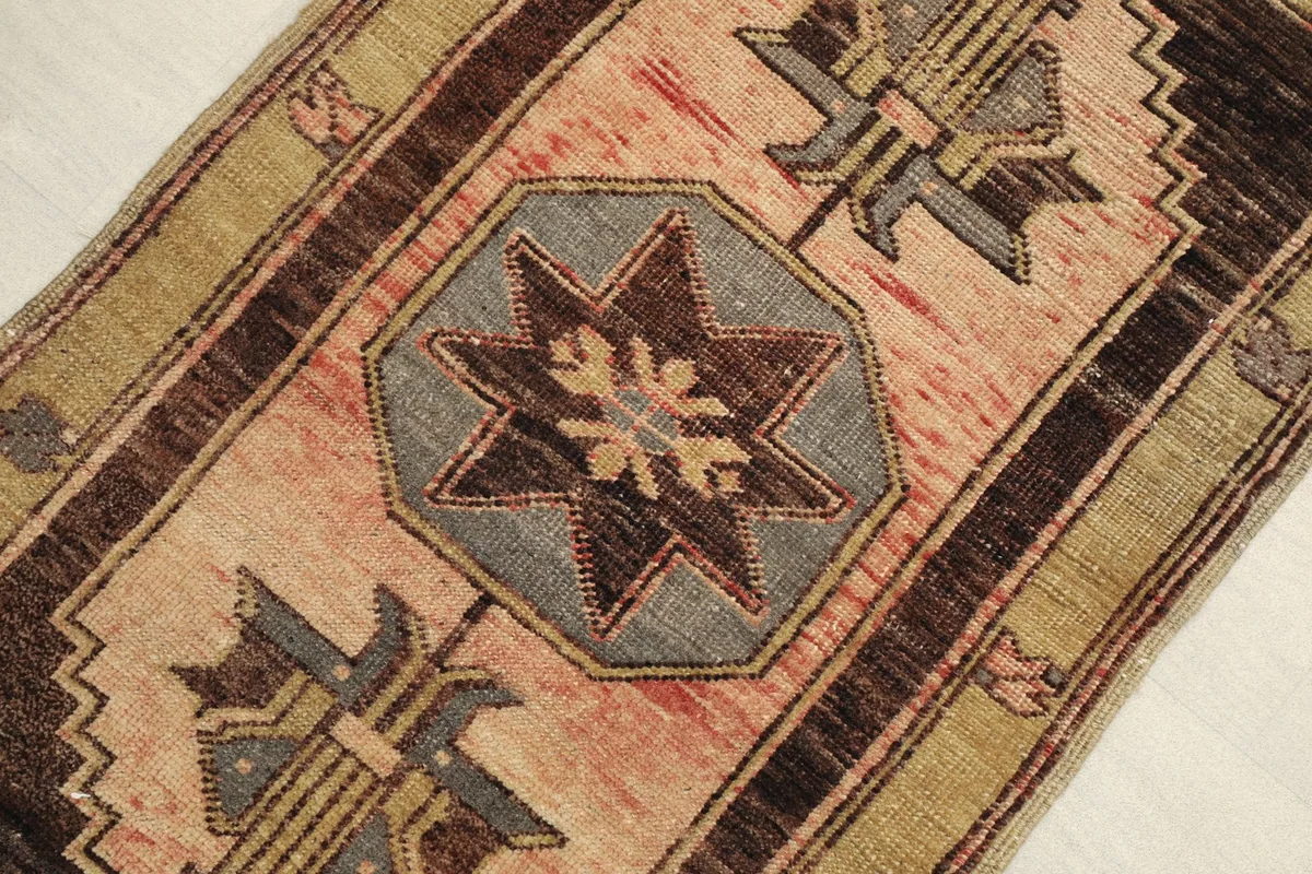 Angled close-up showing the central star motif and surrounding geometric details of the wool doormat
