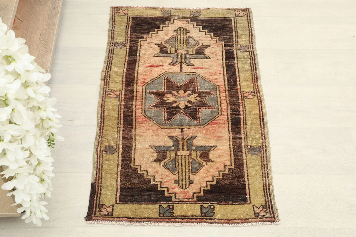Direct overhead shot highlighting the full design of the rose, brown, and olive hand-knotted area rug