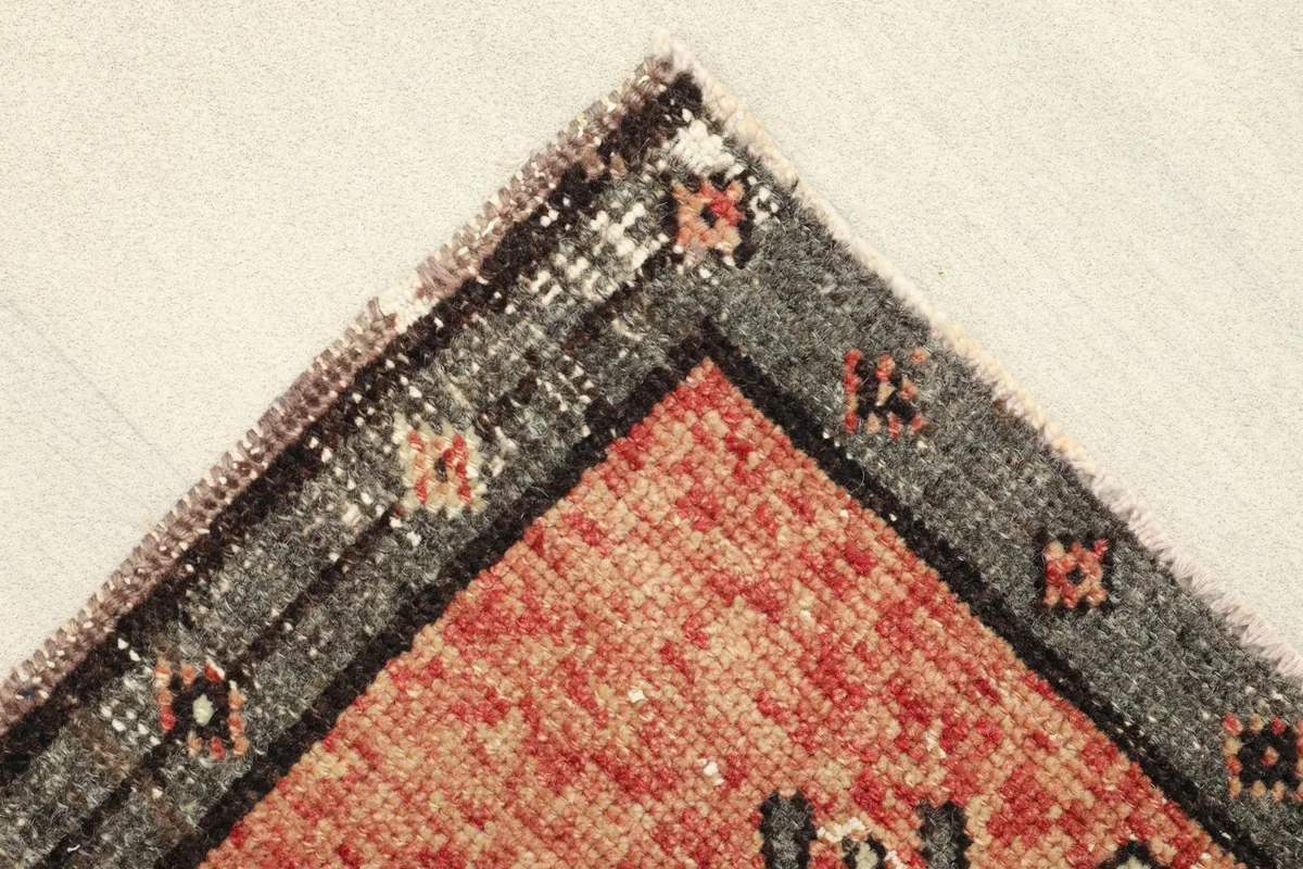 Corner detail showing the gray border and the transition to the rust field.