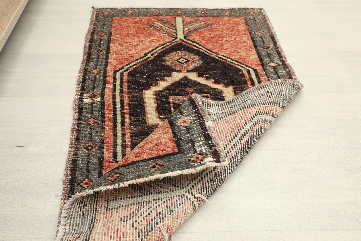 Partial view of the rug's back, showing the hand-knotted cotton foundation and wool pile.
