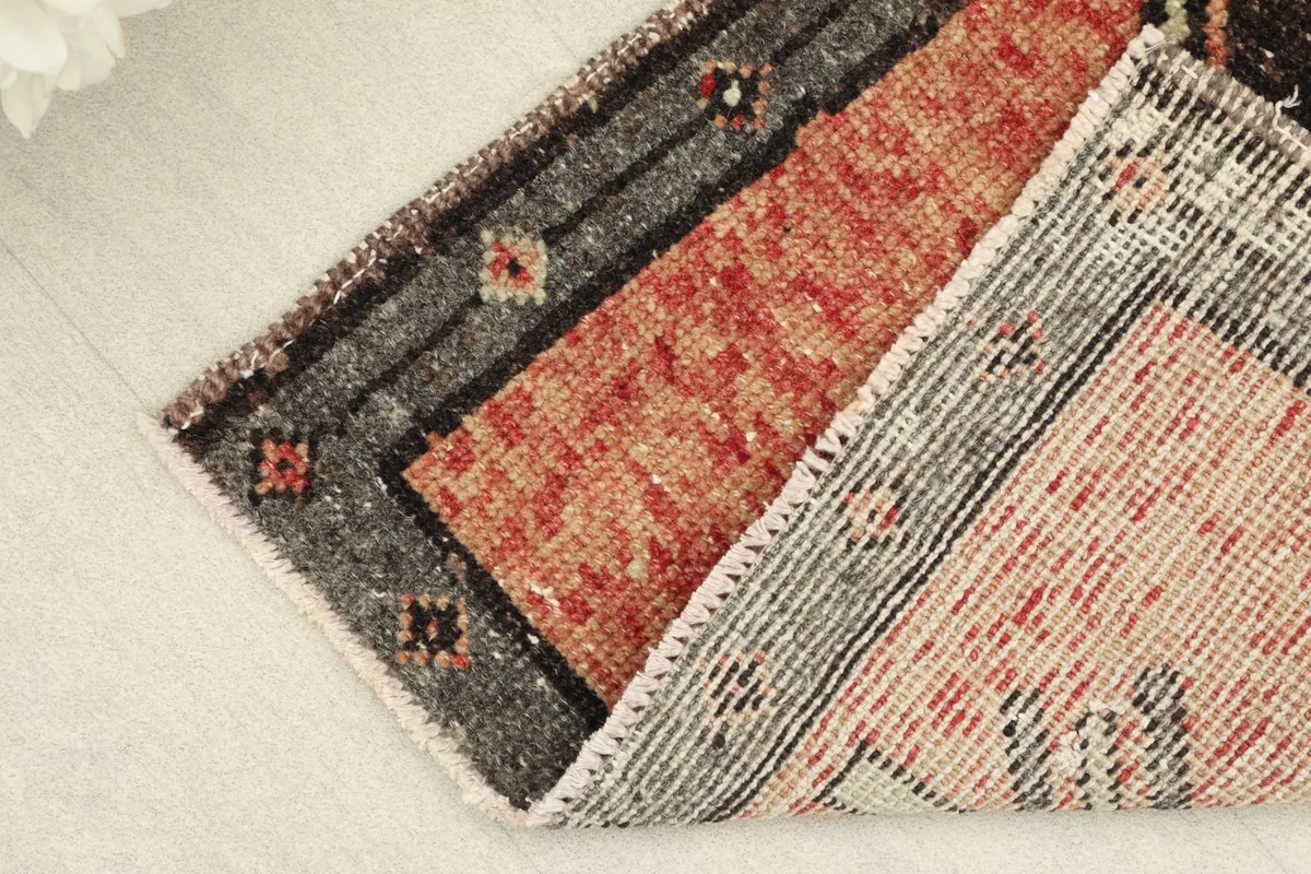 Folded view demonstrating the thickness and flexibility of the vintage wool rug.