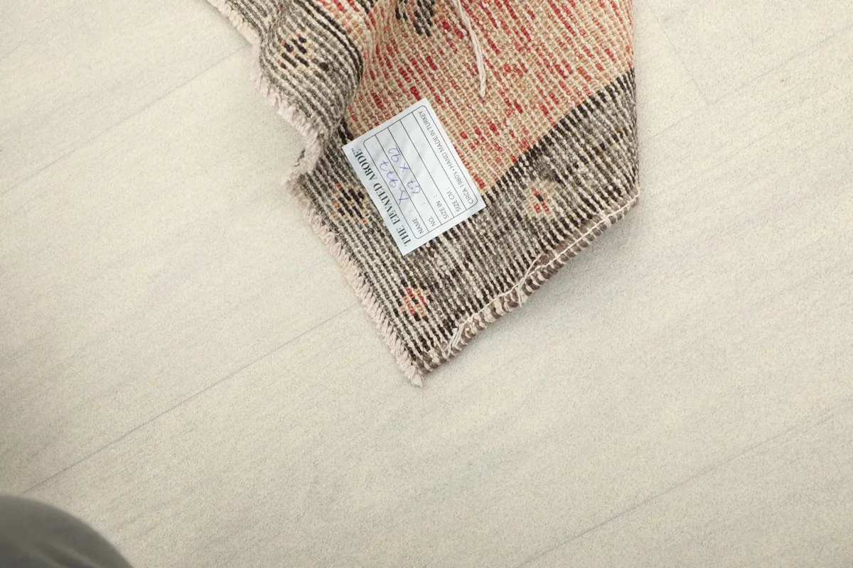 Underside corner detail of the rug, revealing the woven construction and a product label.