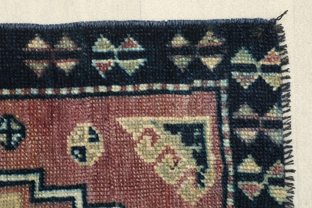 Close-up of another corner showing the patterned navy border and the edge finishing.