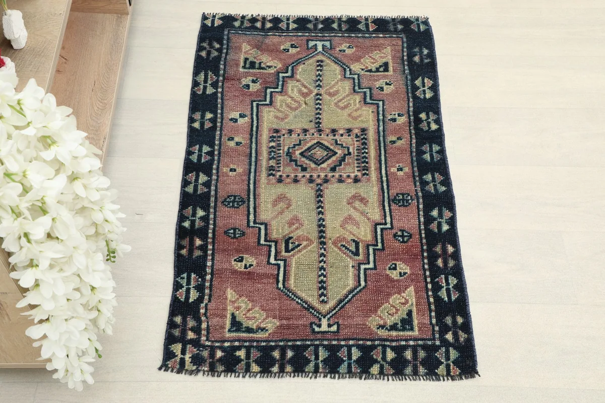 Straight overhead view showcasing the complete rose field and navy geometric border of the doormat.