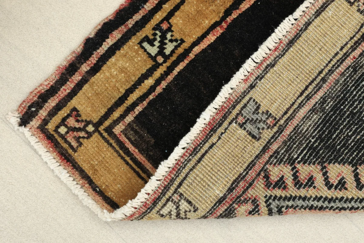 View of the rug's reverse side, showing the cotton foundation and hand-knotted construction.