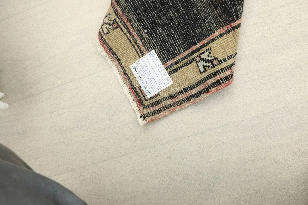 Corner of the rug with a label, indicating its provenance and quality.