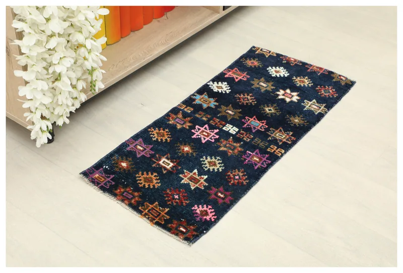 Full top view of the 1'3" x 2'11" navy vintage Anatolian runner with colorful geometric motifs.