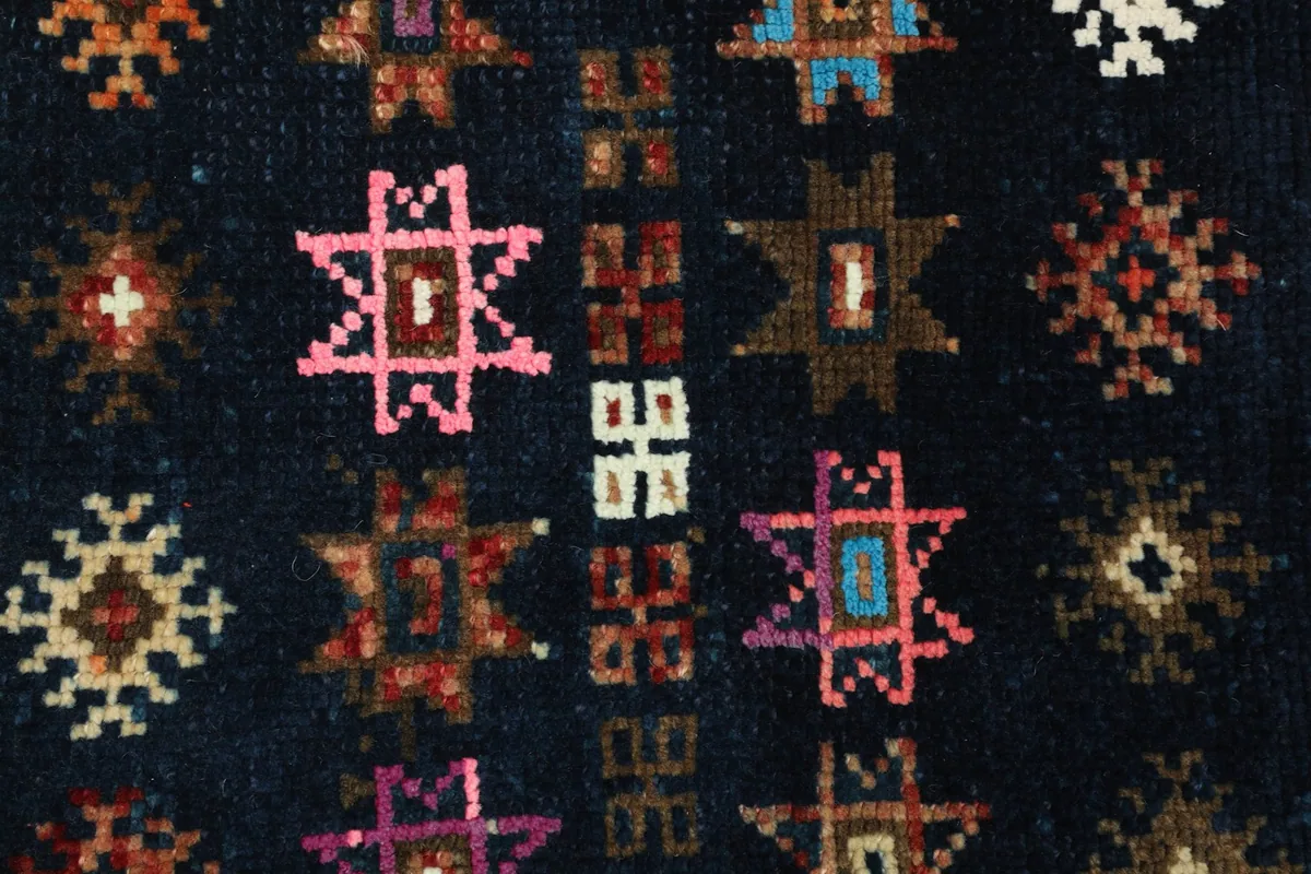 Macro view of the intricate geometric patterns and the texture of the low wool pile.