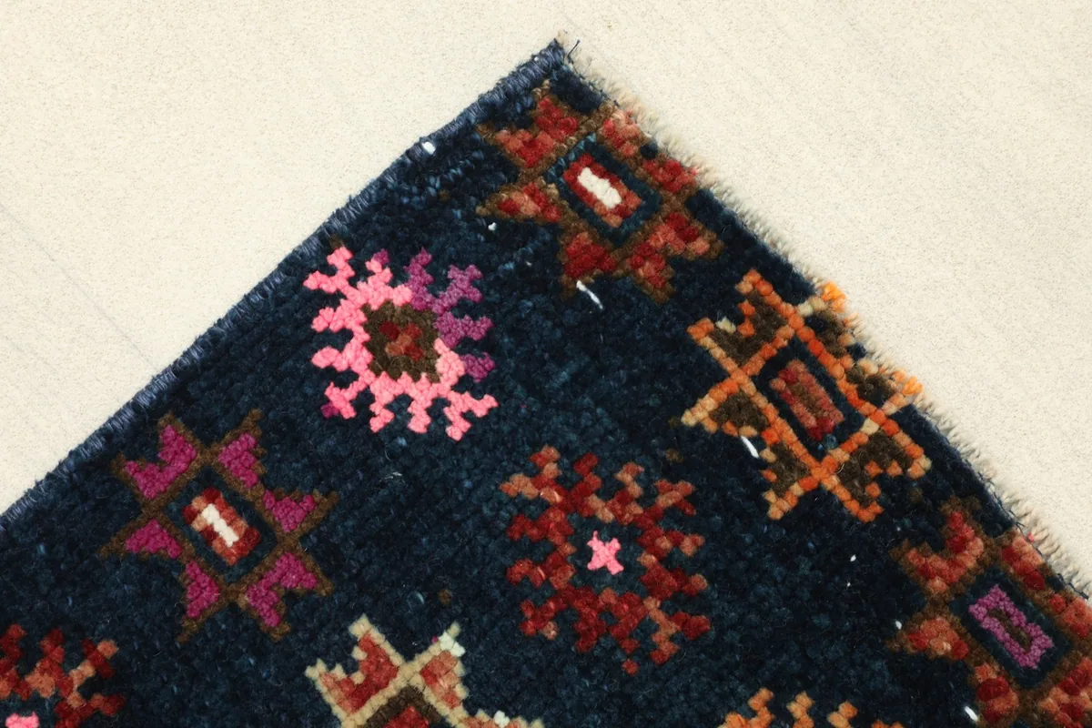Corner detail of the runner, showing the fringe and the edge of the hand-knotted design.