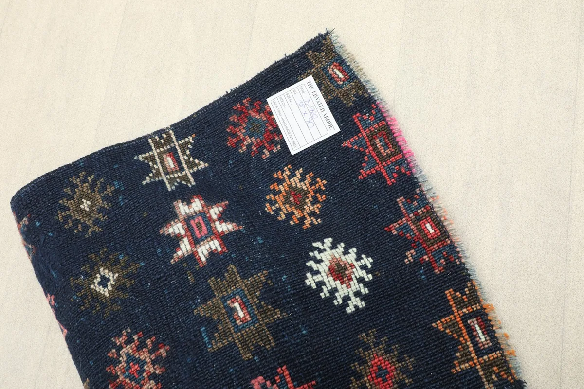A rolled view of the runner, indicating its thickness and the quality of the vintage wool.
