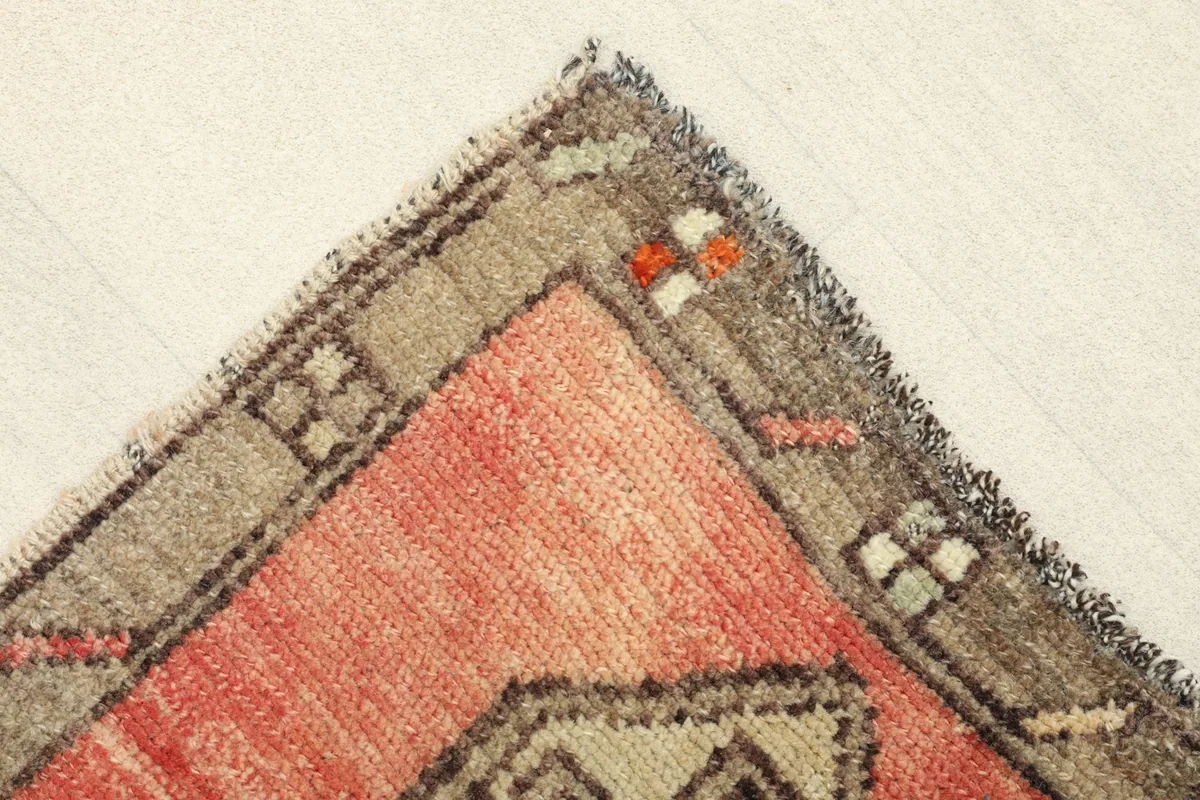 Corner detail of the rug showing the gray border and subtle color variations