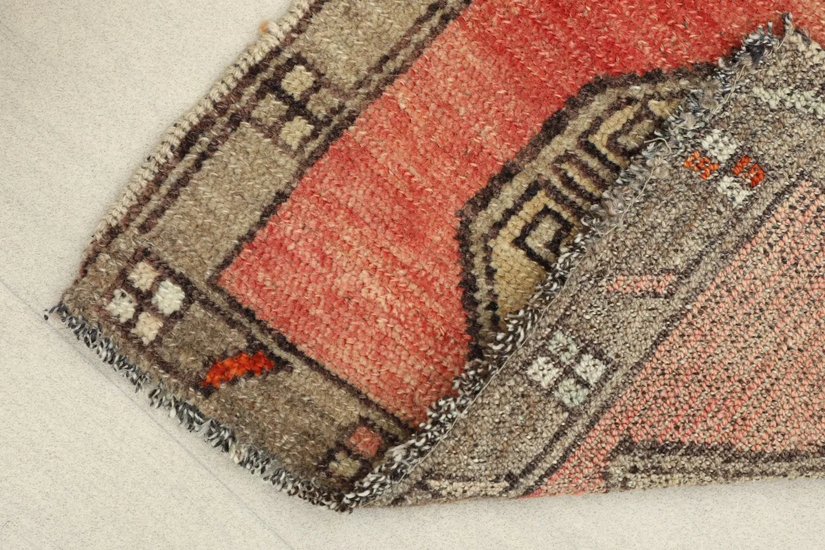 Folded corner of the rug, illustrating its flexibility and the texture of the wool pile