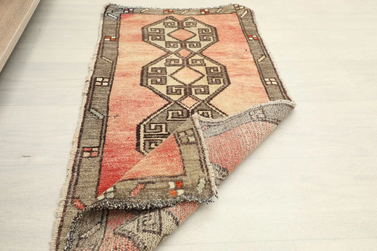Partially folded rug on a white floor, showing the full design and material quality