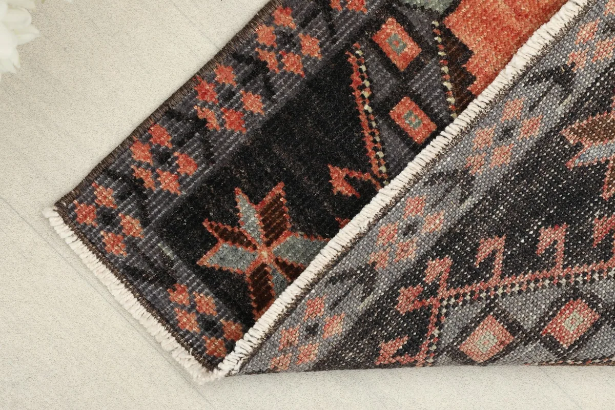 Rug folded to reveal the cotton foundation and the reverse side, showing the hand-knotted construction.