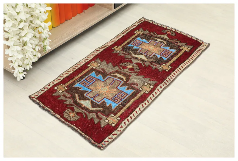 Full top view of the vintage red and blue geometric Anatolian rug on a white background.