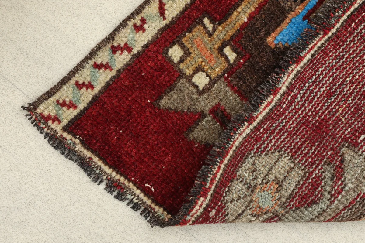 Close-up of the low wool pile and the hand-knotted construction, showing the texture and wear.