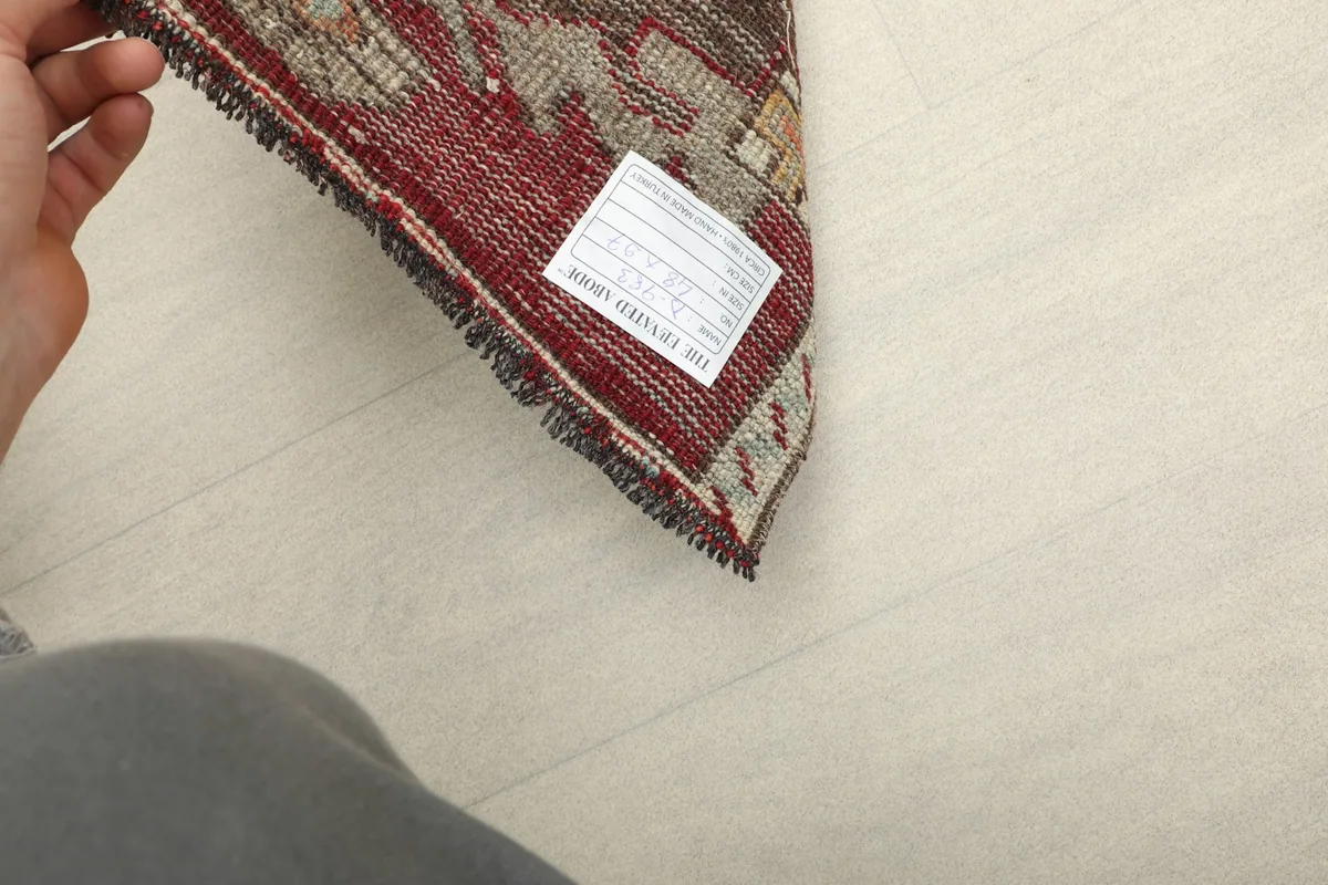View of the back of the rug, showing the cotton foundation and the label with rug information.