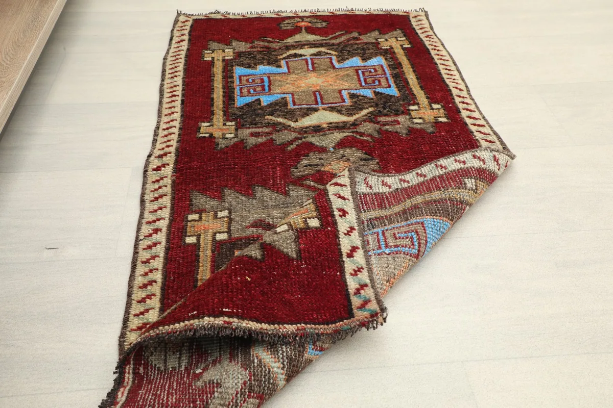 The rug partially folded, illustrating its flexibility and the detailed design on both the top and underside.