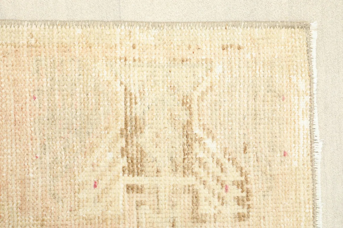 Close-up of a distinct geometric pattern near the edge, showcasing the hand-knotted texture