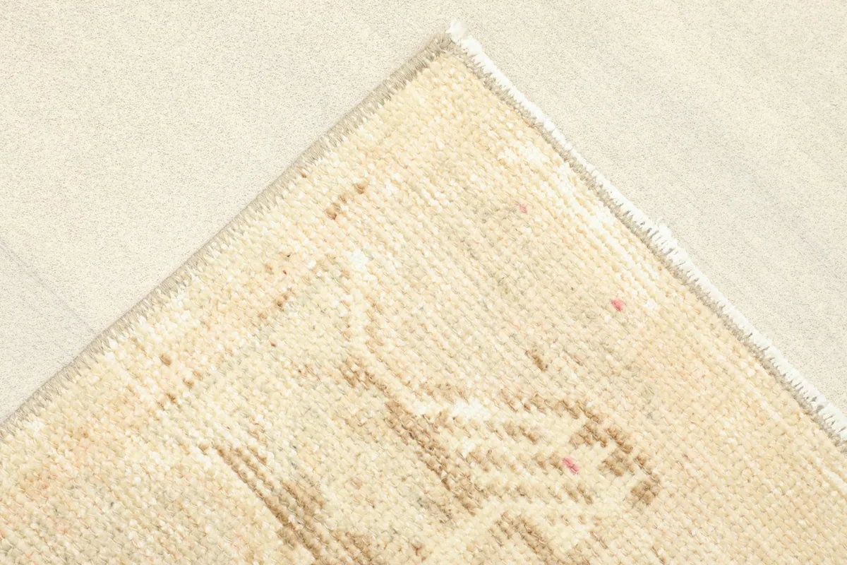 Corner detail showing the finished edge of the rug and a glimpse of the cotton foundation