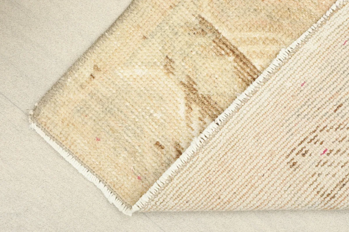 View of the underside of the rug, revealing the woven cotton foundation and hand-knotted construction