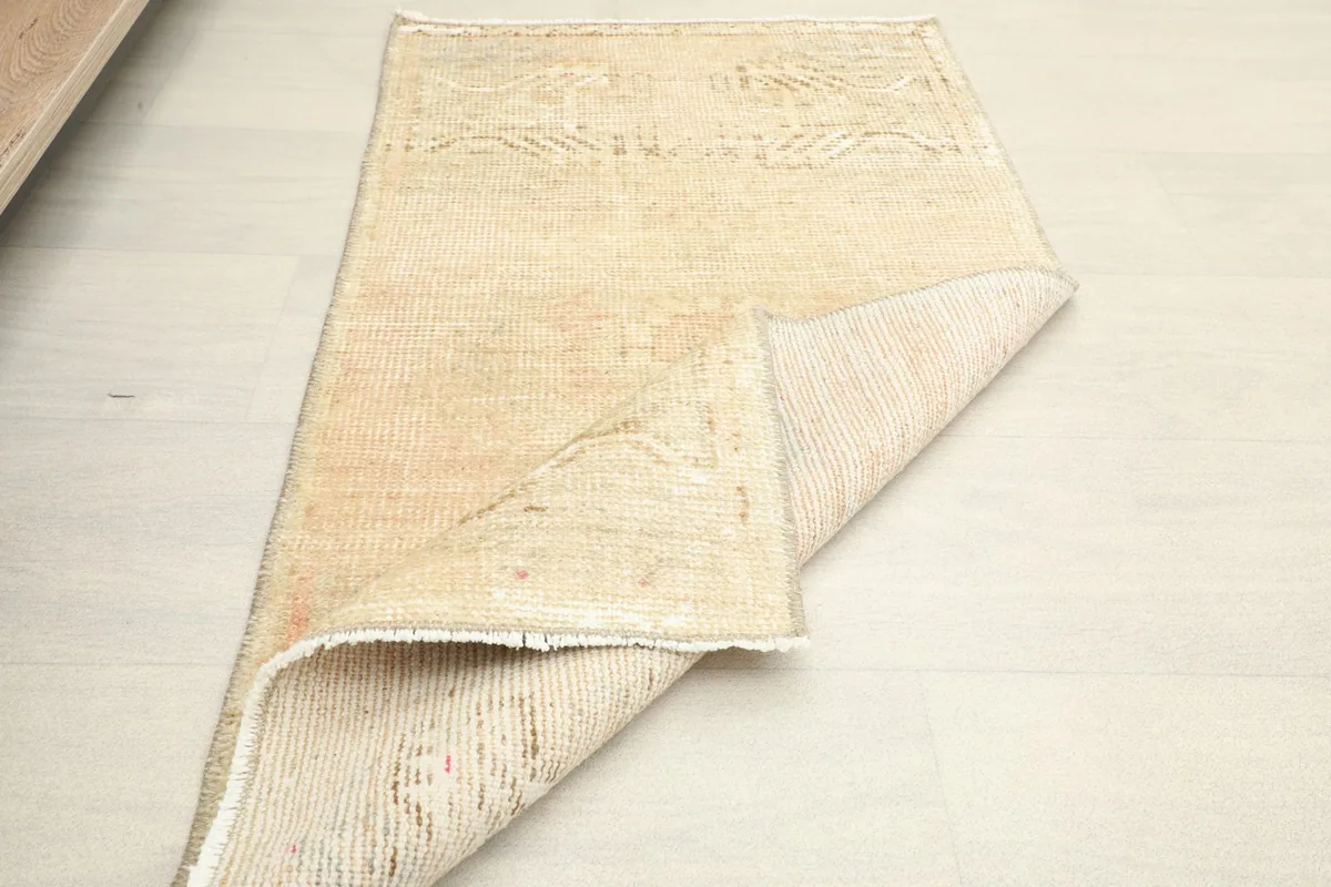 The rug partially folded to show its flexibility and the thickness of the wool pile