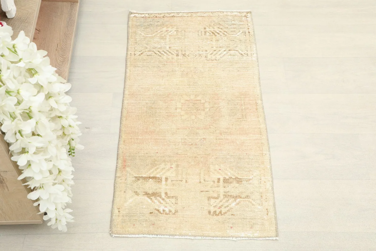 Overhead view of the small hand-knotted rug, showing its rectangular shape and faded patterns