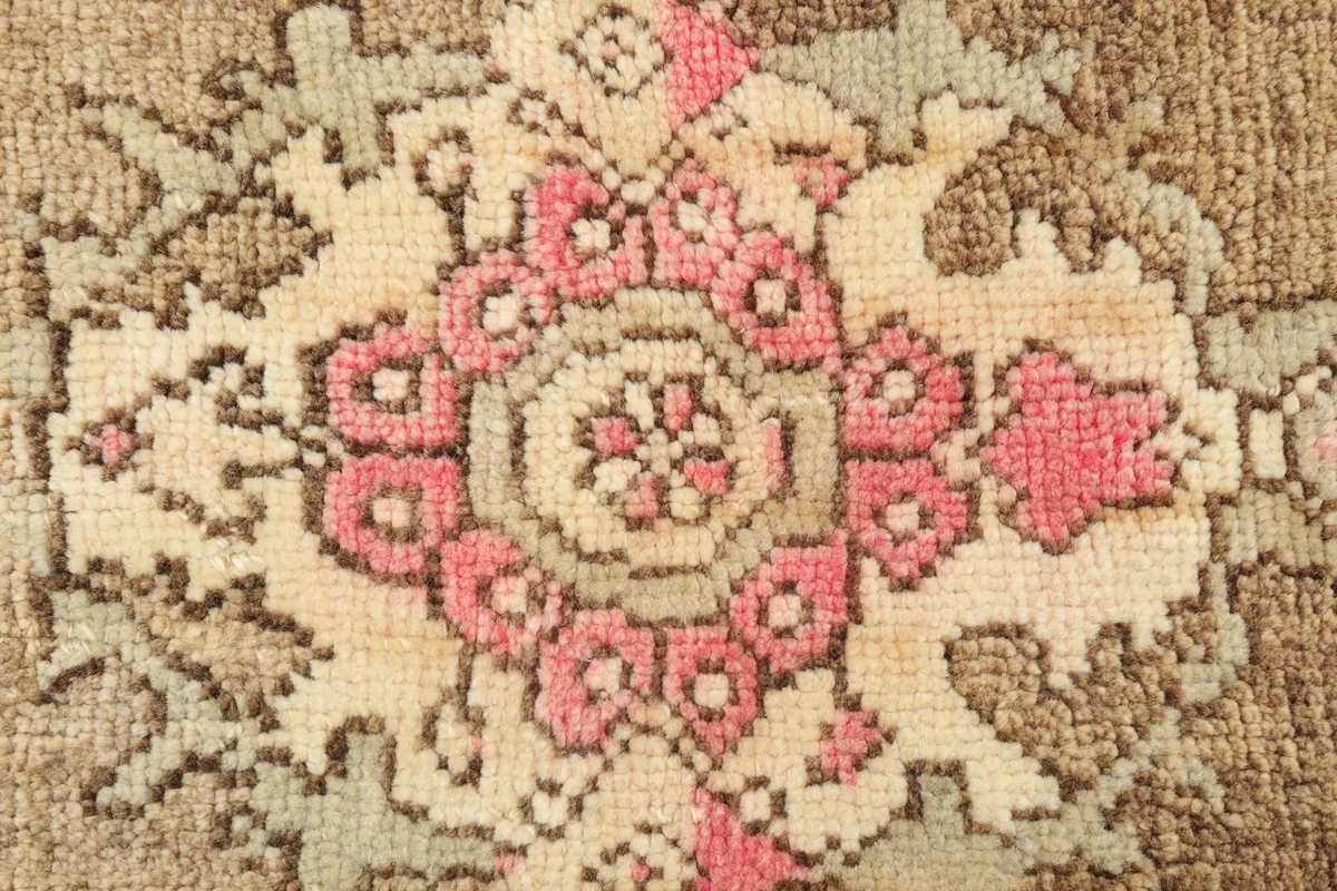 Close-up detail of the central medallion pattern with pink, ivory, and light green colors