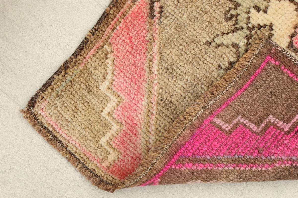 View of the rug's low wool pile texture and the hand-knotted construction