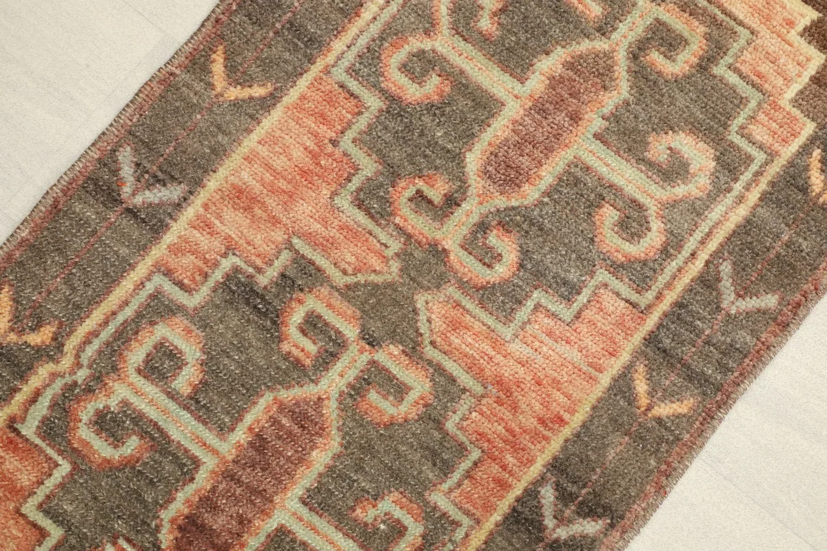 Close-up detail of the brown field and orange, rust, beige geometric motifs